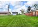 Lush backyard with ample green space, featuring a shed and a view of the home's exterior at 2610 S Sheridan Ave, Indianapolis, IN 46203