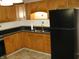 Charming kitchen with wooden cabinets, dark countertops, and a black refrigerator at 3510 Maura Ct, Indianapolis, IN 46235