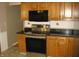 Kitchen showcasing stainless steel stove and microwave with wooden cabinets and dark counters at 3510 Maura Ct, Indianapolis, IN 46235