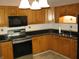 Cozy kitchen features stainless steel appliances, tile countertops, and bright wooden cabinets at 3510 Maura Ct, Indianapolis, IN 46235