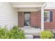 Inviting front porch with brick facade, black door and decorative plants, creating a warm entrance at 3582 Fieldhurst Ln, Plainfield, IN 46168