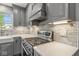 Elegant kitchen featuring a stainless steel range, quartz countertops, subway tile backsplash, and updated cabinetry at 3582 Fieldhurst Ln, Plainfield, IN 46168