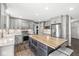 Modern kitchen featuring an island with a butcher block countertop and seating, stainless steel appliances, and stylish gray cabinets at 3582 Fieldhurst Ln, Plainfield, IN 46168