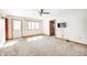 Cozy living room with neutral carpeting, ceiling fan, TV, and ample natural light from the windows at 3913 E Cr 600 S, Clayton, IN 46118