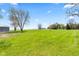 Large, expansive backyard features lush green grass, mature trees, and a storage building off to the side at 4155 S State Rd 39, Lebanon, IN 46052