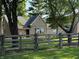 Brick home is framed by a charming wooden fence and mature shade trees at 4155 S State Rd 39, Lebanon, IN 46052