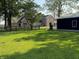 Beautiful property featuring a brick home, a charming wooden fence, and a dark outbuilding on a well-manicured lawn at 4155 S State Rd 39, Lebanon, IN 46052