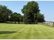 Expansive front yard with lush lawn, mature trees, and a charming wooden fence at 4155 S State Rd 39, Lebanon, IN 46052