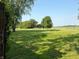 Expansive front yard with lush lawn, mature trees, and a charming wooden fence at 4155 S State Rd 39, Lebanon, IN 46052