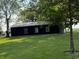 Side view of a modern dark-colored outbuilding with a stone foundation at 4155 S State Rd 39, Lebanon, IN 46052