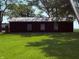 A modern dark-colored outbuilding with three windows stands on a large manicured lawn at 4155 S State Rd 39, Lebanon, IN 46052