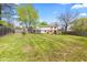 Expansive backyard featuring a well-manicured lawn, deck with a red umbrella, and mature trees at 4322 Matrea More Ct, Indianapolis, IN 46254