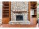 Close-up shot of a stone fireplace with a wooden mantel and built-in shelving at 4322 Matrea More Ct, Indianapolis, IN 46254