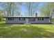 Charming home with a gray brick exterior, black trim, metal roof, and a well-manicured front yard at 4450 Bridgefield West Dr, Plainfield, IN 46168