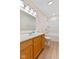 Bright bathroom features a wooden vanity, mirror, and shower-tub combo at 4525 Shelbyville Rd, Indianapolis, IN 46237