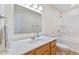 Bright bathroom features a wooden vanity, mirror, and shower-tub combo at 4525 Shelbyville Rd, Indianapolis, IN 46237