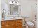 Bright bathroom features a wooden vanity, mirror, and shower-tub combo at 4525 Shelbyville Rd, Indianapolis, IN 46237