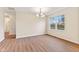 Bright dining room featuring wood floors, a modern chandelier, and a large window providing ample natural light at 4525 Shelbyville Rd, Indianapolis, IN 46237