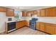Well-equipped kitchen with plenty of wood cabinets, a modern range, and a view from the window over the sink at 4525 Shelbyville Rd, Indianapolis, IN 46237