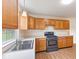 Well-lit kitchen featuring wood cabinets, modern appliances, and a view from the window over the sink at 4525 Shelbyville Rd, Indianapolis, IN 46237