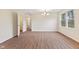 Spacious living room with hardwood flooring, a modern light fixture, and a bright window at 4525 Shelbyville Rd, Indianapolis, IN 46237