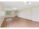 Open-concept living room with wood floors and ample natural light streaming through the large window at 4525 Shelbyville Rd, Indianapolis, IN 46237