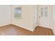 Bright living room featuring beautiful wood-look floors, a large window, and a white door at 4525 Shelbyville Rd, Indianapolis, IN 46237