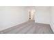 Bedroom with neutral carpet and white walls, leading to a doorway with natural light from the hallway at 4718 E Shadowbrook Dr, Camby, IN 46113