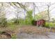 Large backyard with mature trees, small shed, and a partially paved area at 476 Southgate Dr, Greenwood, IN 46143