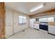 Cozy kitchen area with white appliances and cabinetry, window above the sink, and tile flooring at 476 Southgate Dr, Greenwood, IN 46143