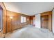 Bright living room featuring wood-paneled walls, carpet floors, and natural light from windows at 476 Southgate Dr, Greenwood, IN 46143
