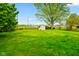 Spacious backyard with a storage shed, green lawn, and mature trees offering a serene outdoor setting at 507 S Grant St, Brownsburg, IN 46112