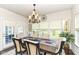 Bright dining room with a decorative chandelier and views of the backyard through the large window at 5158 Montview Way, Noblesville, IN 46062