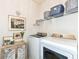 Bright laundry room featuring modern appliances, open shelving with baskets, and decorative accents at 5158 Montview Way, Noblesville, IN 46062