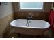 Bright bathroom featuring a freestanding tub with elegant fixtures, tile flooring and a window with natural light at 5361 Ashby Ct, Greenwood, IN 46143