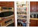 Pantry featuring organized shelving and ample storage space next to double ovens at 5361 Ashby Ct, Greenwood, IN 46143