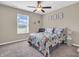 Neutral bedroom with floral bedding, ceiling fan, and bright window at 546 Freedom Dr, Pittsboro, IN 46167