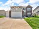 Inviting two-story home featuring a three-car garage and well-manicured lawn at 546 Freedom Dr, Pittsboro, IN 46167