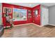 Vibrant living room featuring a bright red accent wall, window, and hardwood floors at 546 Freedom Dr, Pittsboro, IN 46167