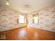 Bright bedroom with hardwood floors, large windows, and unique wallpaper, offering natural light and charm at 5829 Lasalle St, Indianapolis, IN 46220