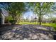 Long driveway leading to a spacious backyard with mature trees and a basketball hoop at 5829 Lasalle St, Indianapolis, IN 46220