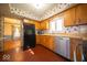 The kitchen features classic wood cabinetry, stainless steel appliances and floral wallpaper at 5829 Lasalle St, Indianapolis, IN 46220