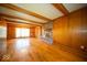 Bright living room with wood paneling, a brick fireplace, hardwood floors, and beamed ceiling at 5829 Lasalle St, Indianapolis, IN 46220