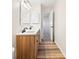 Bathroom with wood-look floors and a double vanity with modern fixtures and bright lighting at 6026 Oakbrook Ln, Indianapolis, IN 46254