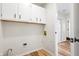 Bright laundry room with white cabinets, wood-look floors, and utility connections at 6026 Oakbrook Ln, Indianapolis, IN 46254