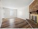 Spacious living room boasts elegant wood flooring, a classic fireplace, and ample natural light, creating a warm ambiance at 6026 Oakbrook Ln, Indianapolis, IN 46254
