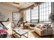 Bright living room with hardwood floors, large windows and a stationary bike for exercise at 624 E Walnut St # 46, Indianapolis, IN 46204