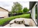 A view of a lush backyard with green grass, trees, and a concrete table and chairs set on a patio at 660 Sun Valley Ct, Indianapolis, IN 46217