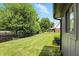Well-manicured backyard with a long lawn bordered by mature trees and a black metal fence at 660 Sun Valley Ct, Indianapolis, IN 46217