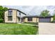 Charming stone house with lush front lawn, two-car garage, and well-maintained landscaping at 660 Sun Valley Ct, Indianapolis, IN 46217